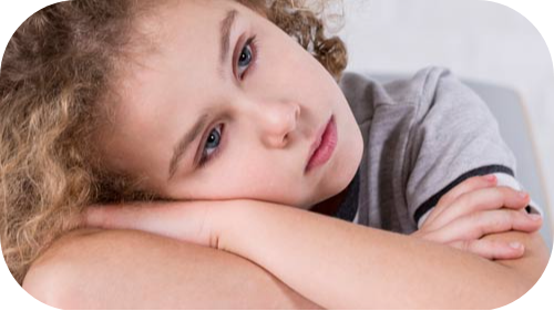 Young girl resting her head on her crossed arms with unhappy expression.