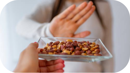 Image of hand in "stop" justure in front of tray with peanuts.